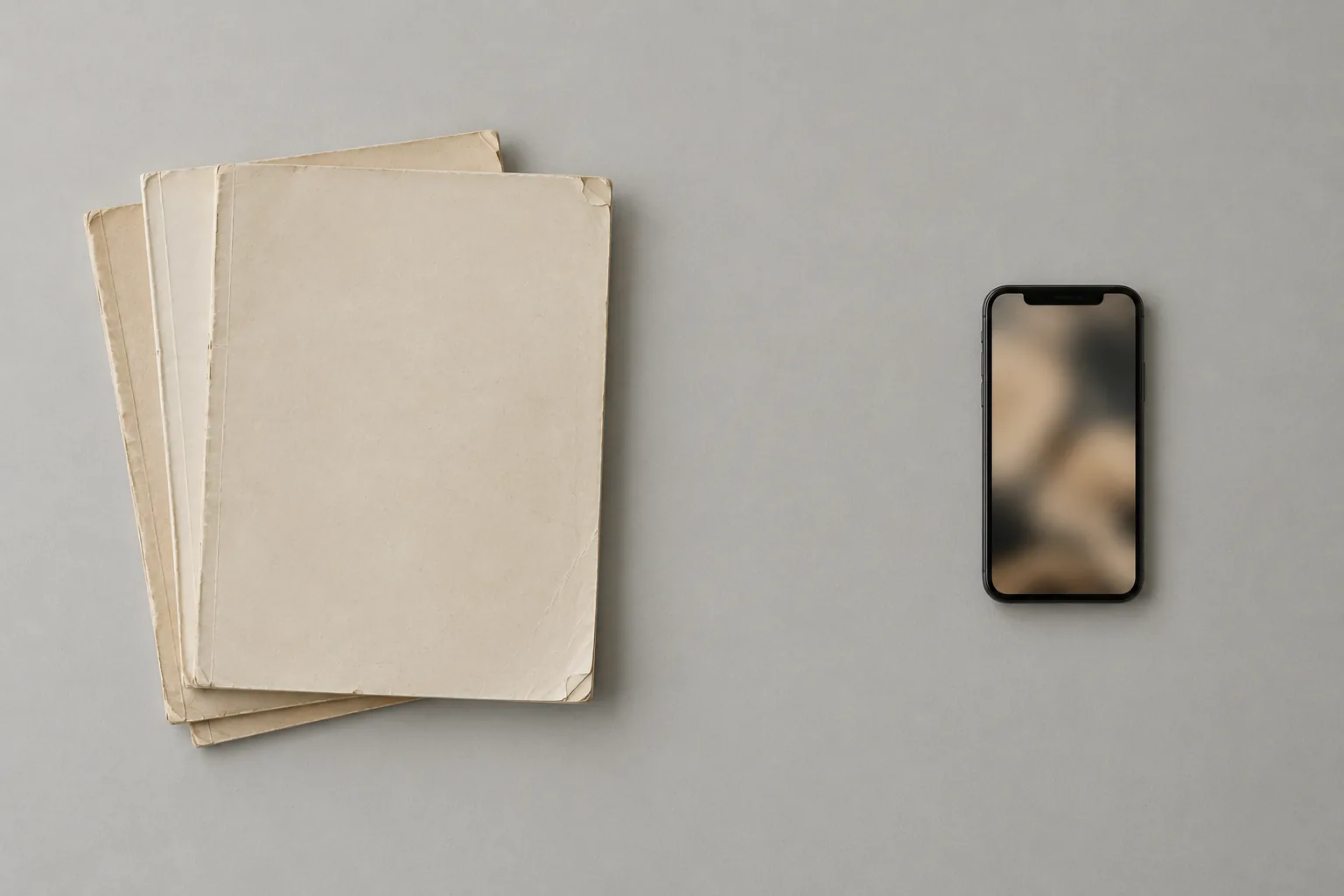 A stack of old blank hairstyle magazines on the left and a smartphone on the right, separated by empty space.
